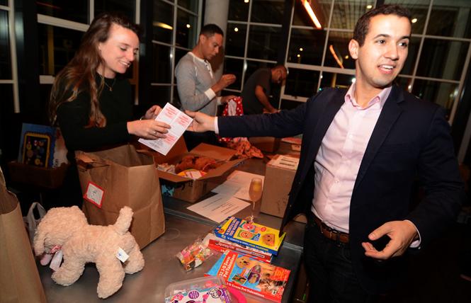 Greg Margida, right, co-founder of the Valentine Project, helped pack gift boxes for distribution to children in the Bay Area at a packaging party January 31. Other volunteers included, from left, Caitlin Keep, Erick Felder, and Amit Lal. Photo: Rick Gerharter