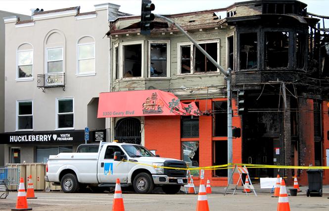 A Pacific Gas & Electric truck sits outside the burned-out Hong Kong Lounge II, right, and Huckleberry Youth Programs, left, which sustained damage during a gas pipe explosion fire February 6. Photo: Heather Cassell