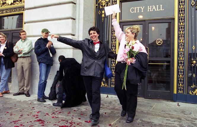 A newly-married couple triumphantly exit San Francisco City Hall following their wedding ceremony on February 15, 2004. Photo: Rick Gerharter