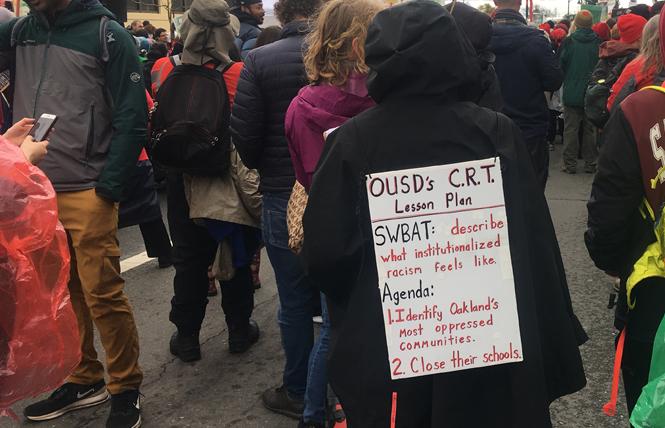 Protesters assembled alongside Roots International Academy February 26. On the sign, CRT stands for critical race theory and SWBAT is an educational acronym for Student Will Be Able To. Photo: Christina A. DiEdoardo