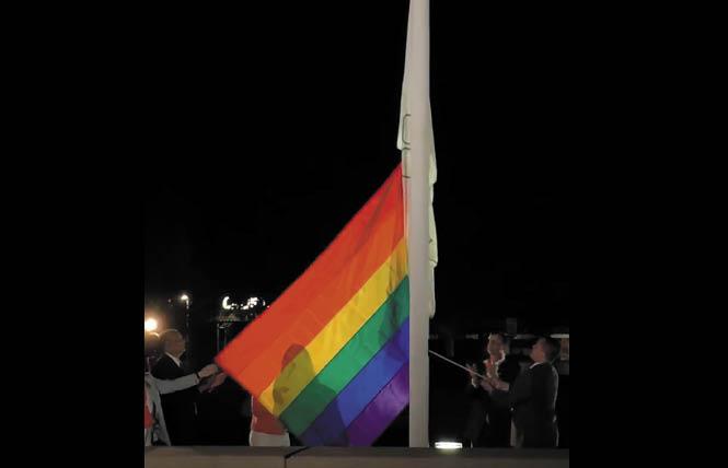 Dublin Mayor David Haubert, second from right, and City Councilman Shawn Kumagai, holding rope, raise the rainbow flag outside City Hall Tuesday Night. Photo: Courtesy Facebook