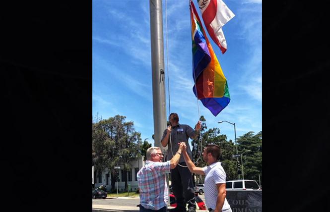 Alameda County Supervisor Scott Haggerty, left, joined Emeryville City Council man John Bauters to raise the rainbow flag at the county office building Tuesday. Photo: Courtesy Twitter