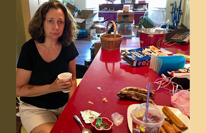 Angela Padilla sits at her dining table where an alleged burglar left drug paraphernalia, foreground, after ransacking and stealing items from her home over the weekend. Photo: Sari Staver