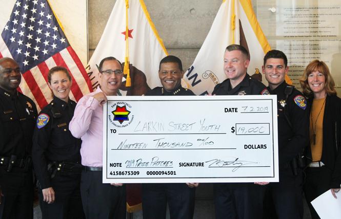 San Francisco Police Chief William Scott, center, joined Larkin Street Youth Services Executive Director Sherilyn Adams, at right, and other officers to present the check from Pride patch sales. Photo: Courtesy SFPD