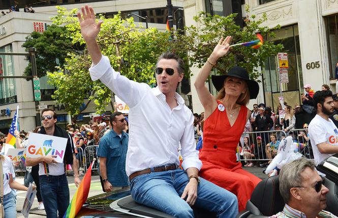 Governor Gavin Newsom, shown riding in the San Francisco Pride parade with his wife, Jennifer Siebel Newsom, included funding in his state budget for LBQ women's health. Photo: Rick Gerharter