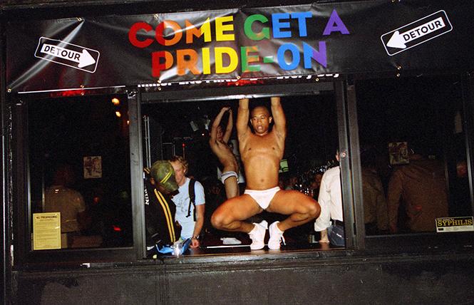 Dancers perform in the window of the Detour Bar in June 2005, the bar's last year. photo: Rick Gerharter