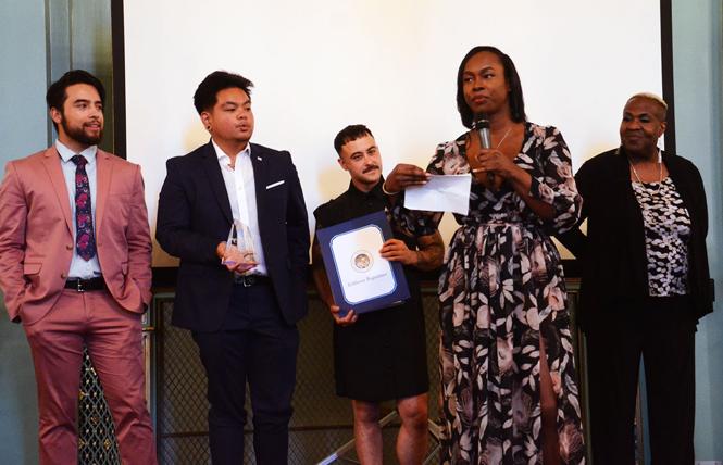 Akira Jackson accepts the Bill Kraus Leadership Award on behalf of the Our Trans Home SF coalition during the Harvey Milk LGBTQ Democratic Club annual dinner Monday, July 29. Other members of the coalition joined Jackson on stage. Photo: Rick Gerharter