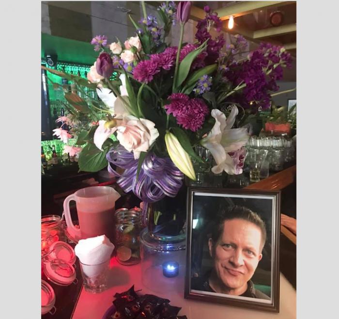 A floral arrangement next to a photo of Frank Schumacher.