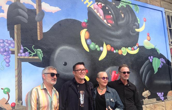 Peter Toscani, left, Donald Harvey, Meredith Clark, and Michael Ritter stand in front of the restored "Laughing Gorilla" mural during the August 10 unveiling. Photo: Veronica Dolginko