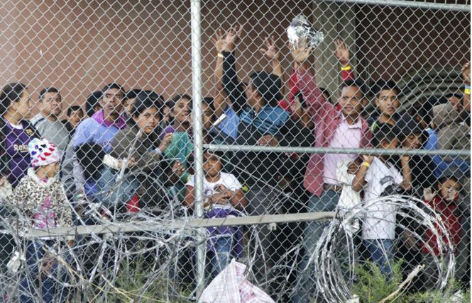 In this March 27, file photo, Central American migrants wait for food in a pen erected by U.S. Customs and Border Protection in El Paso, Texas. Photo: Courtesy AP
