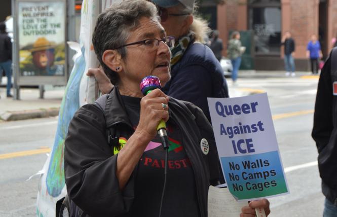 QUIT organizer Carla Schick speaks in front of Immigration and Customs Enforcement's San Francisco office Monday during the Queers Melt ICE rally. Photo: Samantha Laurey
