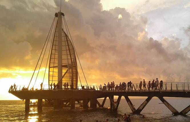 Visitors are drawn to sunset at the pier on Los Muertos Beach. Photo: Ed Walsh