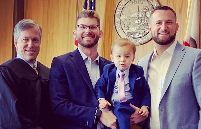 Sacramento City Councilman Steve Hansen, right, and his partner, Michael McNulty, hold their son, Henry, after the judge finalized the adoption. Photo: Courtesy Facebook