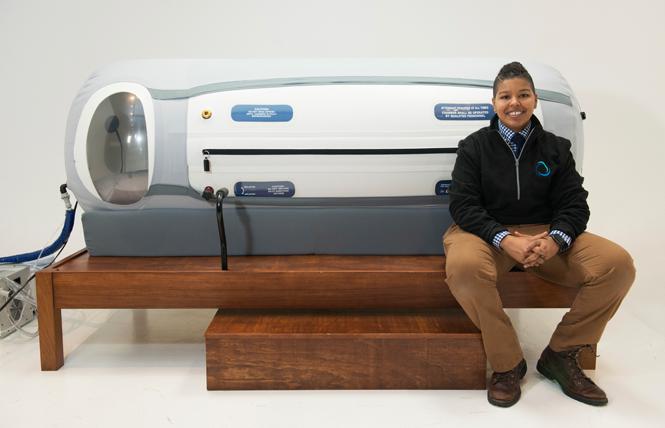 Alex Williams sits by a hyperbaric chamber; she recently opened a larger spa in Oakland. Photo: Courtesy Alex Williams