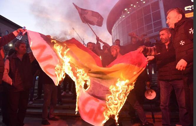 Anti-gay demonstrators burn a rainbow flag before the Tbilisi premiere of "And Then We Danced" on November 8. Photo: Courtesy RFE/RL