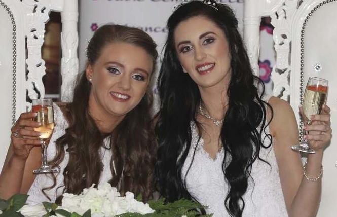 Robyn Peoples, left, and Sharni Edwards pose together after becoming the first same-sex couple to marry in Northern Ireland February 11. Photo: Liam McBurney/PA via AP