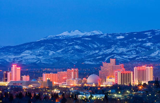 Downtown Reno is lit up at night with the snowcapped Sierra Nevada Mountains in the background. Photo: Andy/Adobe Stock