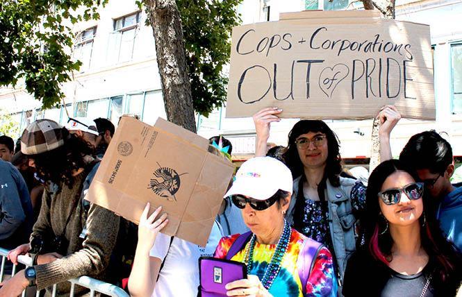 Sylvia, center, raised their sign "Cops + Corporations Out of Pride" along Market Street during last year's San Francisco's Pride parade after other protesters halted the event for about an hour. Photo: Heather Cassell  