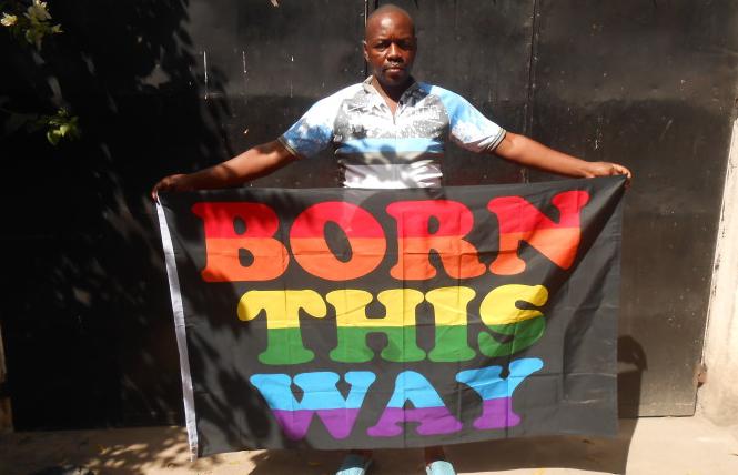 A Tanzanian holds up a "Born This Way" banner. Photo Credit: Courtesy LGBT Voice