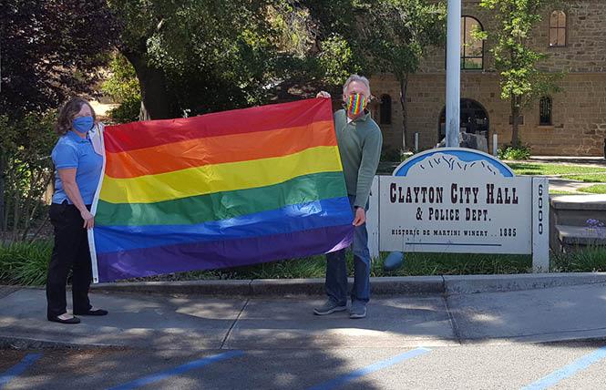Clayton Mayor Julie Pierce, left, and Councilman Carl Wolfe hold the rainbow flag shortly before it was raised in front of City Hall Monday, June 1. Photo: Cynthia Laird