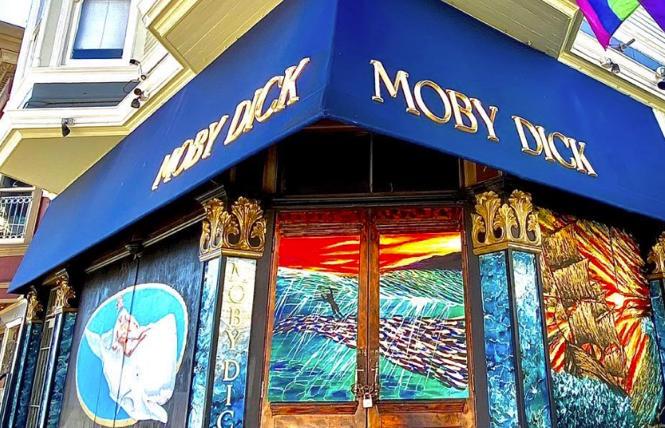 Moby Dick Bar, with recent murals painted on its boarded doors and windows