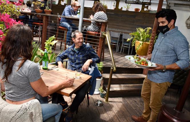 Ramsey Garcia, right, co-owner of Fable, serves Katie Brillault and Rick Holthouse on the patio of the restaurant. Photo: Steven Underhill
