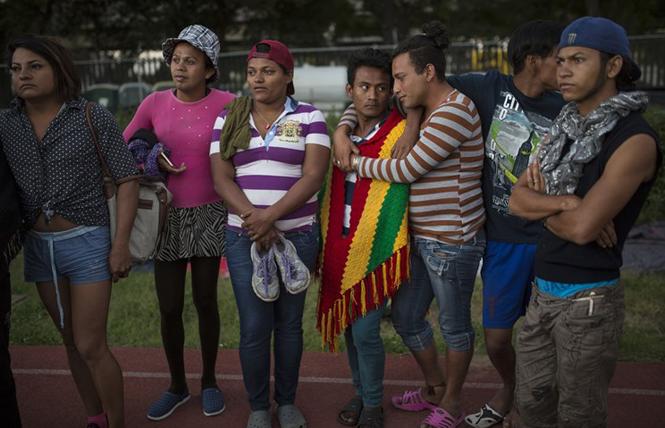 LGBTQ migrants stand on the racetrack at the Jesus Martinez stadium, which was turned into a makeshift shelter for the migrant caravan in Mexico City in 2018. Photo Credit: Courtesy Rodrigo Abd/Associated Press