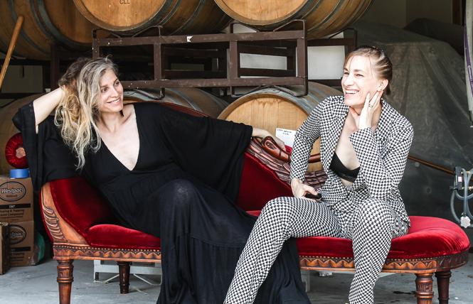Morgan Murphy, left, and her spouse, Maggie Przybylski, sit in front of fermenting equipment and barrels of their cider at Two Broads Cider in San Luis Obispo. Photo: Courtesy Two Broads Cider