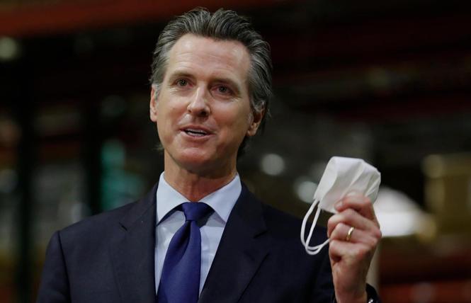 Governor Gavin Newsom held a face mask as he urged people to wear them to fight the spread of the coronavirus during a June news conference in Rancho Cordova, California. Photo: AP/Rich Pedroncelli, Pool