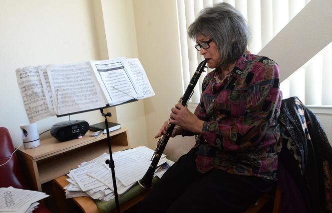 Jasmine Gee plays her clarinet in her apartment. Photo: Rick Gerharter