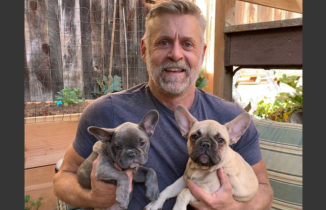 Doug Roenicke holds Indigo, left, and Lila after they were returned to him following a dognapping incident. Photo: Sari Staver