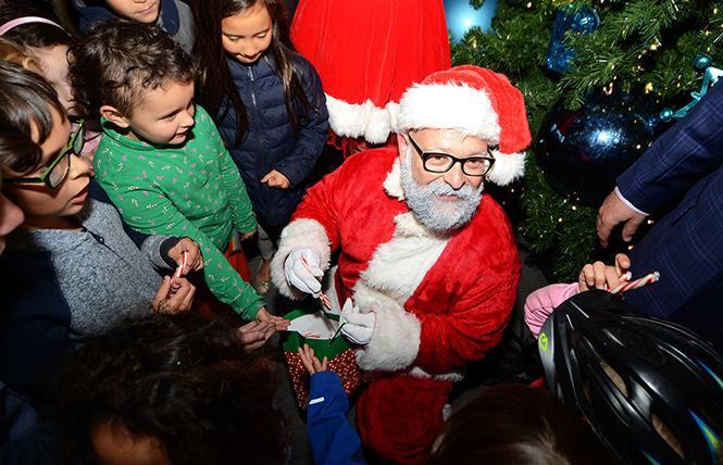 Santa stopped by the annual lighting of the Castro Merchants' holiday tree in 2018 to pass out candy canes to the children who were there. Photo: Rick Gerharter