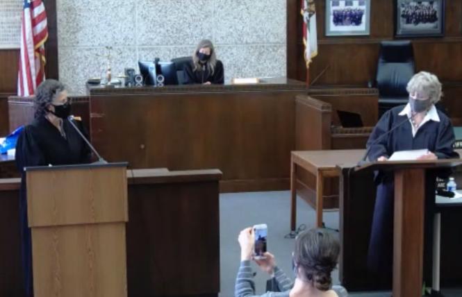 Alameda County Superior Court Judge Elena Condes, left, was sworn in by retired Judge Cecilia Castellanos, right, as Condes' spouse, Danielle, records the proceedings and Presiding Judge Tara Desautels looks on. Photo: Screengrab via BlueJeans.