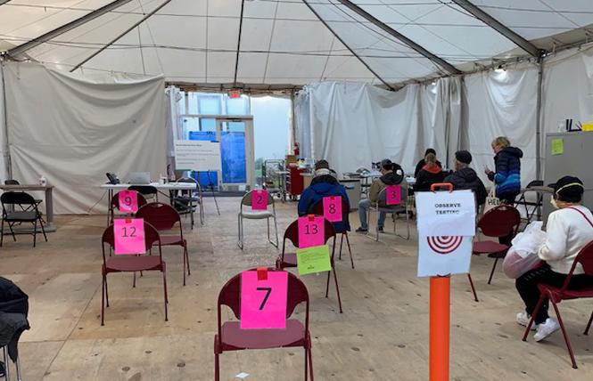 People sit at a COVID vaccine site in San Francisco. Photo: Sari Staver