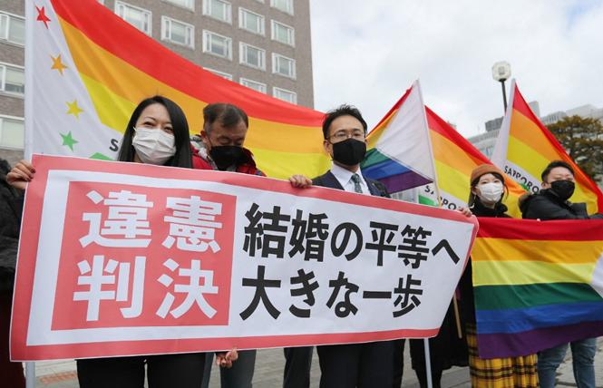 Same-sex marriage advocates celebrated outside the Sapporo District Court March 17 following a landmark ruling that Japan's denial of same-sex marriage is unconstitutional. Photo: Courtesy AFP/STR/JIJI Press