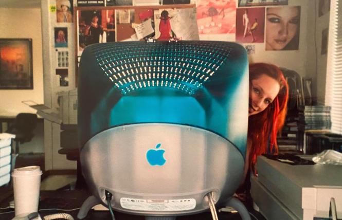 Adriana Roberts peeks out from a Mac at the B.A.R. offices, circa 2000.