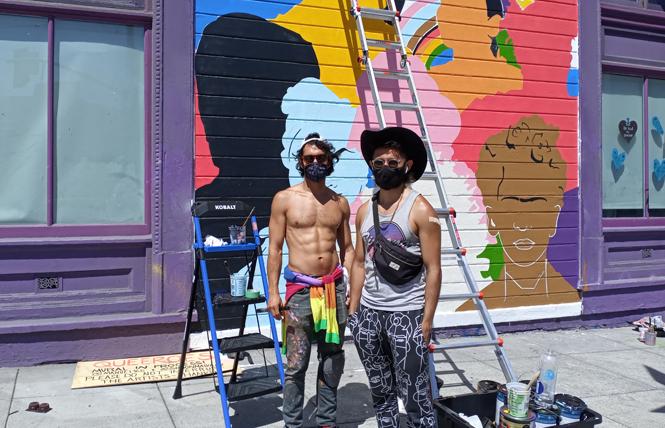 Artists Juan Manuel Carmona, left, and Simón Malvaez work on their new mural on the side of the San Francisco LGBT Community Center. Photo: Scott Wazlowski
