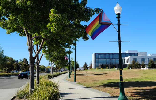 The city of Alameda recently installed Progress Pride flags, alternating with U.S. flags, along a stretch of Webster Street by the College of Alameda. Photo: Cynthia Laird