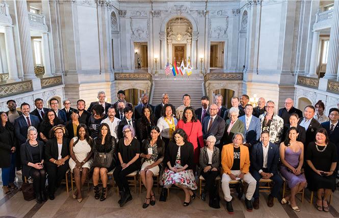 Mayor London Breed, center, joined city officials and the newly sworn in 26-member LGBTQI+ Advisory Committee of the San Francisco Human Rights Commission on the mayor's balcony at City Hall Wednesday, June 23. Photo: Christopher Robledo