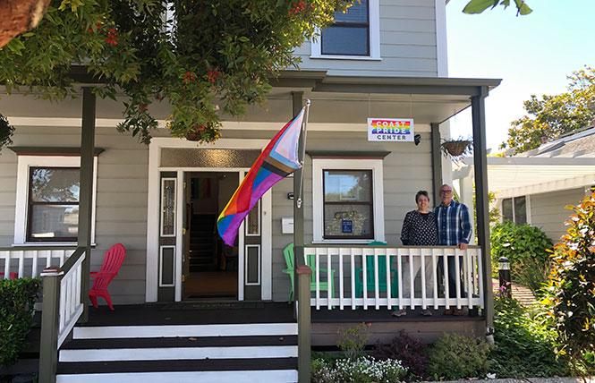 CoastPride co-founder Jenny Walter, left, and founding member David Oliphant sit on the front porch of the recently opened CoastPride Community Center. Photo: Matthew S. Bajko