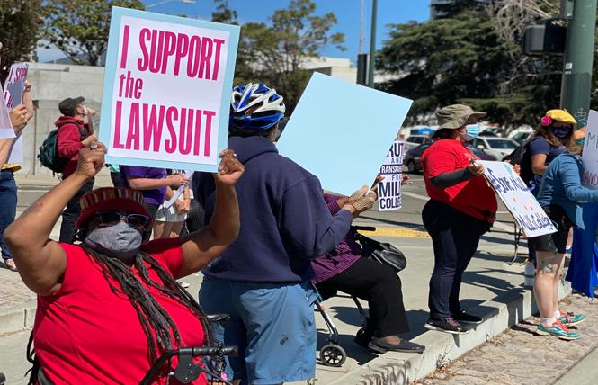 Mills College alumna Nadine Dixon, left, held a sign at a rally August 2 outside the courthouse in Oakland. Photo: John Ferrannini