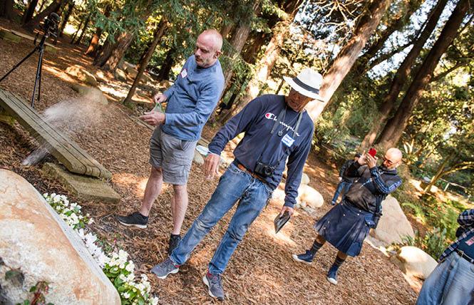 Tim Ray Brown's longtime partner Tim Hoeffgen, left, and Brown's friend Raymond Bordeaux, center, place his ashes on the memorial boulder dedicated to Brown at the National AIDS Memorial Grove in Golden Gate Park Saturday, October 16. Photo: Christopher Robledo