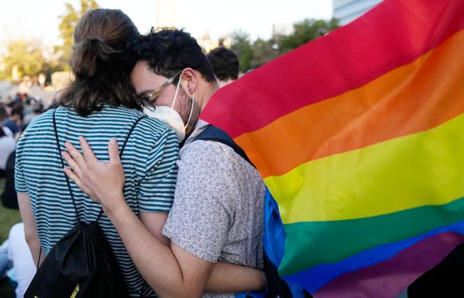 Members of the Movilh - Movement for Homosexual Integration and Liberation - celebrate after lawmakers approved legislation legalizing marriage and adoption by same-sex couples, in Santiago, Chile, on December 7. Photo: Esteban Felix/AP<br>