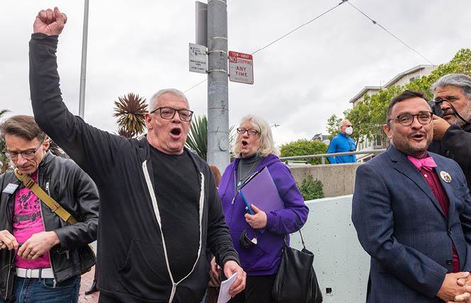 Cleve Jones, second from left, leads a chant during a March 27 rally at Harvey Milk Plaza in the Castro. Assembly candidate David Campos is at right. Photo: Jane Philomen Cleland<br>
