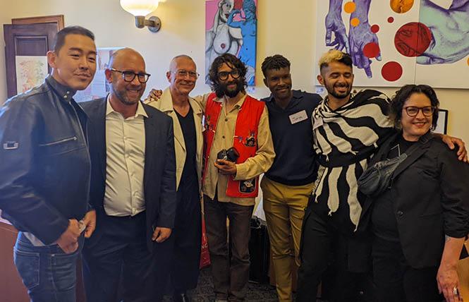 Jun Yang, left, joined Supervisor Rafael Mandelman, Joseph Abbati, Anthony O'Donnell, Serge Gay Jr., Simon Malvaez, and Lea Magdangal at Mandelman's Pride Month kick-off art show; in the background are paintings by Abbati and Magdangal. Photo: Eric Burkett<br>