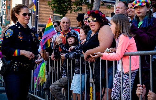 A San Francisco police officer greets Pridegoers at the 2016 San Francisco Pride parade. Photo: Pete Thoshinsky