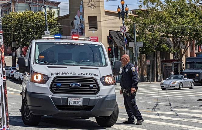 A San Francisco police officer directs a van from the Office of the Chief medical Examiner at the scene of a shooting death aboard a Muni train between the Forest Hill and Castro stations June 22. Photo: Eric Burkett  <br>