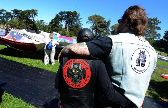 People watched as volunteers unfolded the AIDS Memorial Quilt in Robin Williams Meadow in Golden Gate Park on June 11 as part of the weekend display. Photo: Rick Gerharter
