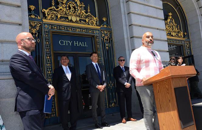 San Francisco AIDS Foundation CEO Tyler TerMeer, Ph.D., speaks about the inadequate federal and state response to the monkeypox virus during a July 12 news conference on the steps of City Hall as District 8 Supervisor Rafael Mandelman stands at left. Photo: Rick Gerharter<br> 