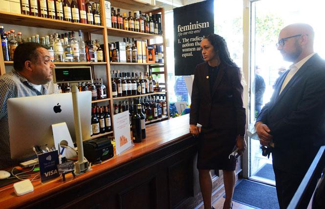 San Francisco District Attorney Brooke Jenkins, center, chats with Joseph Estrada, left, of the Castro Village Wine Co. during her tour of the Castro district, which was led by District 8 Supervisor Rafael Mandelman, right. Photo: Rick Gerharter